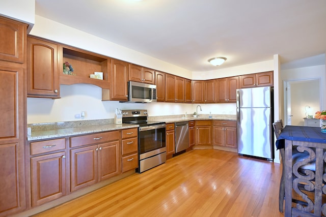 505 N Kenilworth Ave Unit 3, Glen Ellyn, IL 60137 - kitchen with stainless steel appliances, a sink, light wood finished floors, open shelves, and light stone countertops