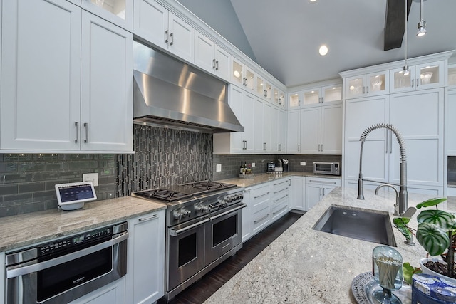 1308 N Wright St, Naperville, IL 60563 - kitchen with range with two ovens, under cabinet range hood, decorative backsplash, white cabinetry, and vaulted ceiling