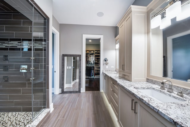 1308 N Wright St, Naperville, IL 60563 - bathroom featuring double vanity, a shower stall, a walk in closet, and wood finished floors
