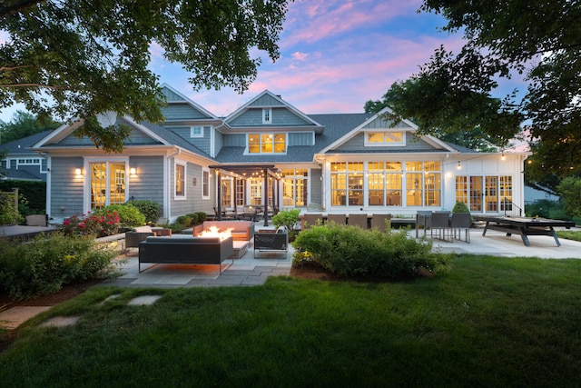 1308 N Wright St, Naperville, IL 60563 - back of property at dusk with an outdoor living space with a fire pit, a patio area, and a lawn
