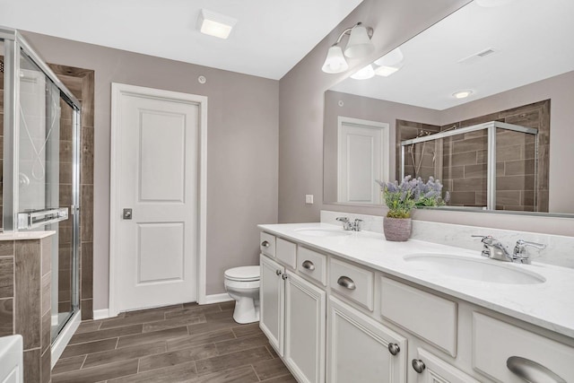 16127 W Switch Grass Rd, Lockport, IL 60441 - bathroom featuring a stall shower, toilet, double vanity, wood finish floors, and baseboards