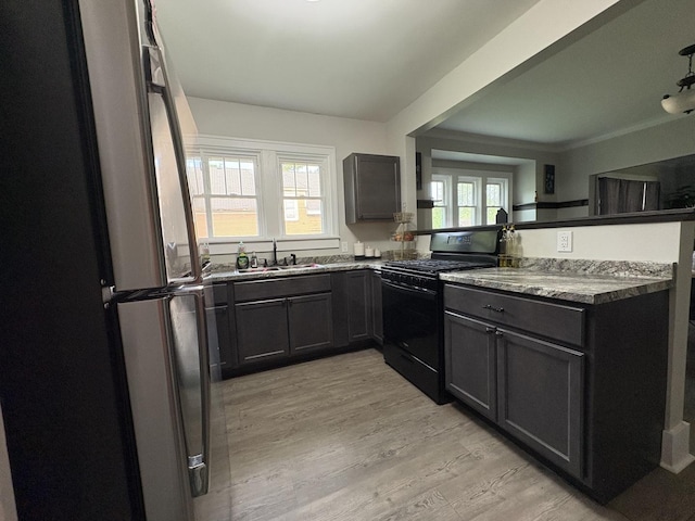 903 E Behrends Ave, Peoria, IL 61603 - kitchen featuring freestanding refrigerator, black range with gas stovetop, a sink, light wood finished floors, and a peninsula