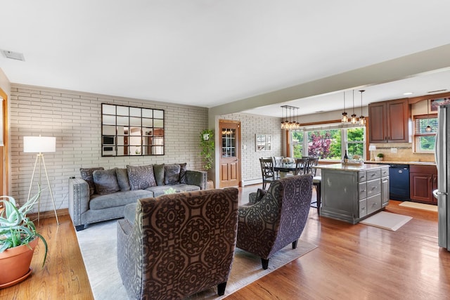 11111 Doogan Ave, Willow Springs, IL 60480 - living area featuring brick wall, light wood-type flooring, and a chandelier