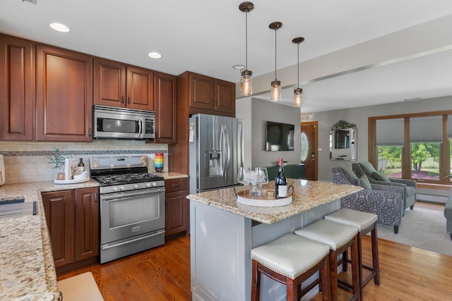 11111 Doogan Ave, Willow Springs, IL 60480 - kitchen featuring appliances with stainless steel finishes, dark wood-style flooring, open floor plan, a breakfast bar, and recessed lighting