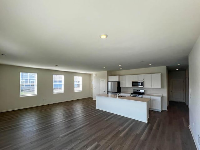 1097 Savannah Ln, Pingree Grove, IL 60140 - kitchen with appliances with stainless steel finishes, open floor plan, white cabinetry, dark wood-style floors, and a kitchen island with sink
