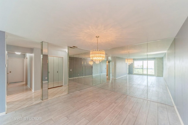 9500 N Washington St Unit 510, Niles, IL 60714 - spare room with a chandelier, light wood-style flooring, and baseboards