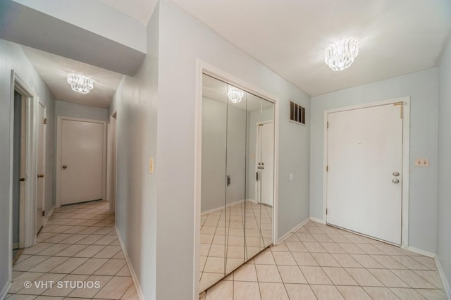 9500 N Washington St Unit 510, Niles, IL 60714 - hallway featuring light tile patterned floors, a chandelier, and baseboards