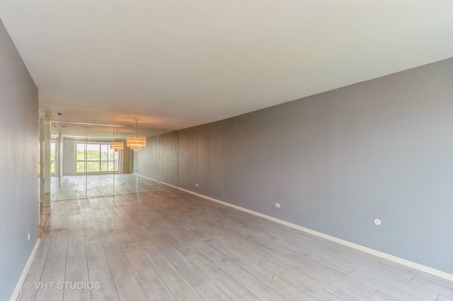 9500 N Washington St Unit 510, Niles, IL 60714 - unfurnished room featuring a chandelier, light wood-type flooring, and baseboards