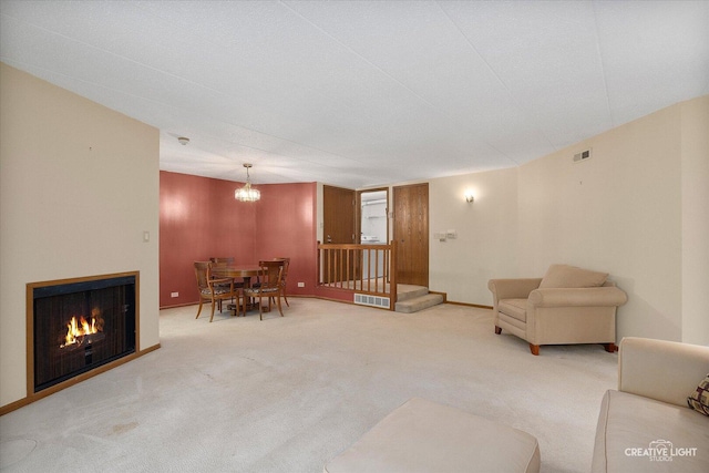 living area with carpet flooring, a chandelier, a warm lit fireplace, and baseboards