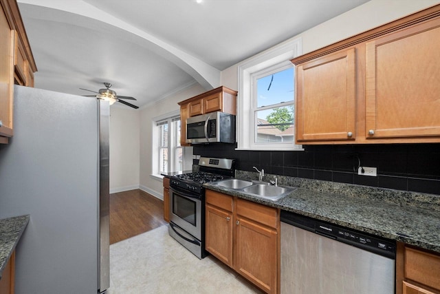 4860 W Warner Ave Unit 1, Chicago, IL 60641 - kitchen with stainless steel appliances, a sink, decorative backsplash, and brown cabinets