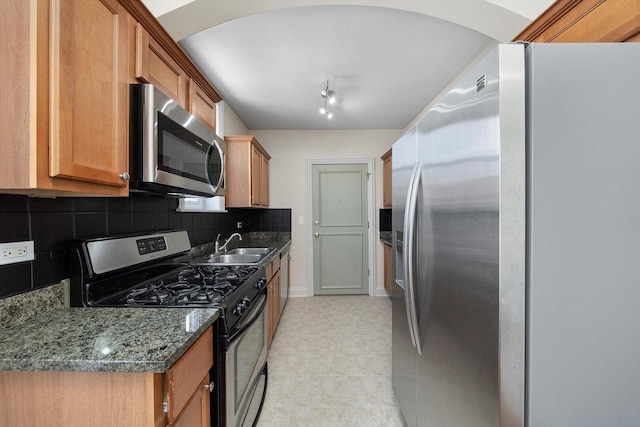 4860 W Warner Ave Unit 1, Chicago, IL 60641 - kitchen with stainless steel appliances, tasteful backsplash, a sink, baseboards, and dark stone countertops