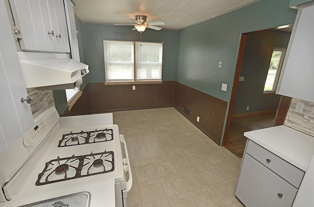 610 E Main St, Ottawa, IL 61350 - kitchen with white gas stove, ceiling fan, wood walls, wainscoting, and light countertops