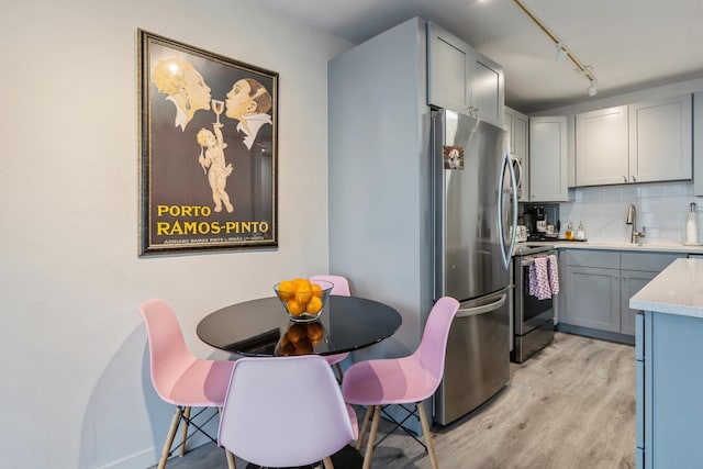 330 W Diversey Pkwy Unit 1209, Chicago, IL 60657 - kitchen featuring stainless steel appliances, light wood-style flooring, backsplash, light countertops, and a sink