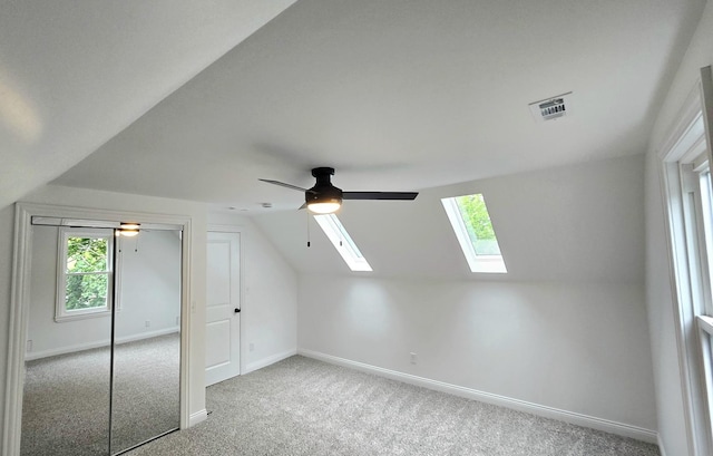additional living space with a skylight, carpet floors, lofted ceiling, a ceiling fan, and baseboards