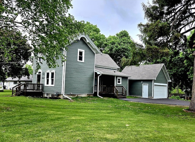 view of front facade with an outdoor structure, a front yard, a garage, and roof with shingles