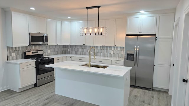 kitchen featuring stainless steel appliances, a sink, light wood-style floors, white cabinetry, and recessed lighting