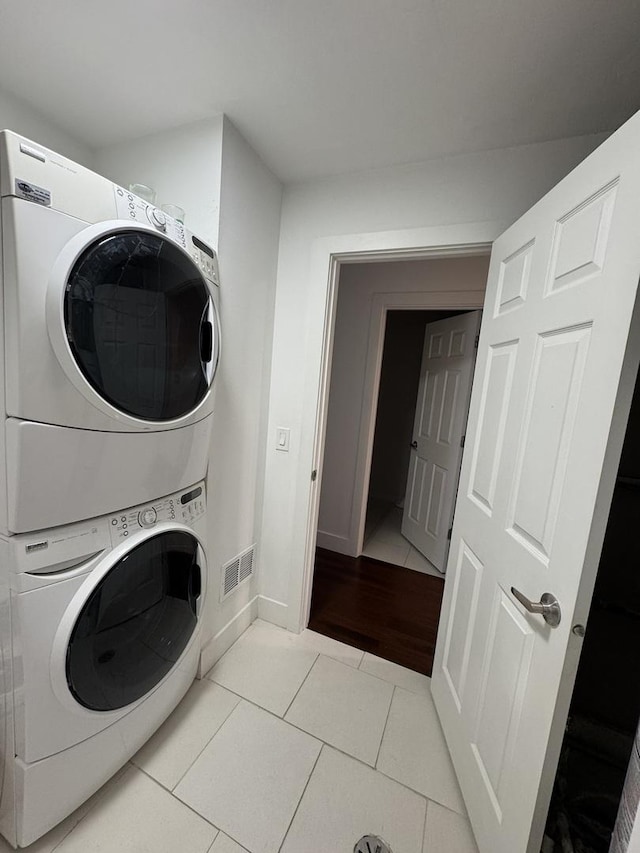 1021 Boxwood Ct Unit C1, Wheeling, IL 60090 - laundry area with stacked washer / dryer, light tile patterned floors, and baseboards