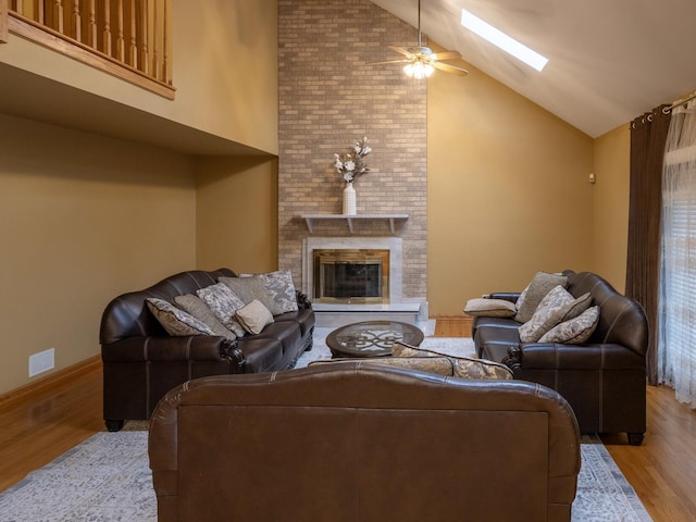 1707 Frediani Ct, Mount Prospect, IL 60056 - living room featuring wood finished floors, ceiling fan, a skylight, a fireplace, and high vaulted ceiling