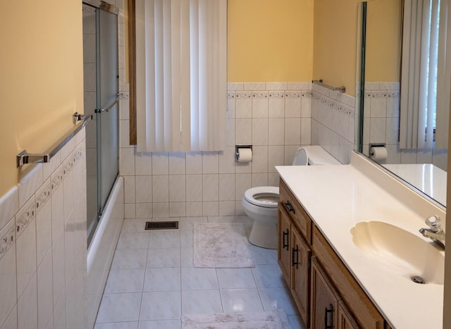 1707 Frediani Ct, Mount Prospect, IL 60056 - full bathroom featuring tile walls, toilet, vanity, tile patterned floors, and a wainscoted wall