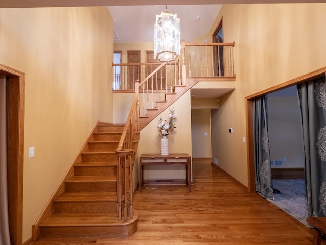 1707 Frediani Ct, Mount Prospect, IL 60056 - stairs with a chandelier, wood finished floors, a high ceiling, and baseboards