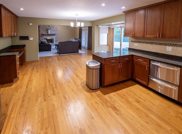 1707 Frediani Ct, Mount Prospect, IL 60056 - kitchen with light wood-type flooring, a peninsula, a fireplace, a chandelier, and recessed lighting