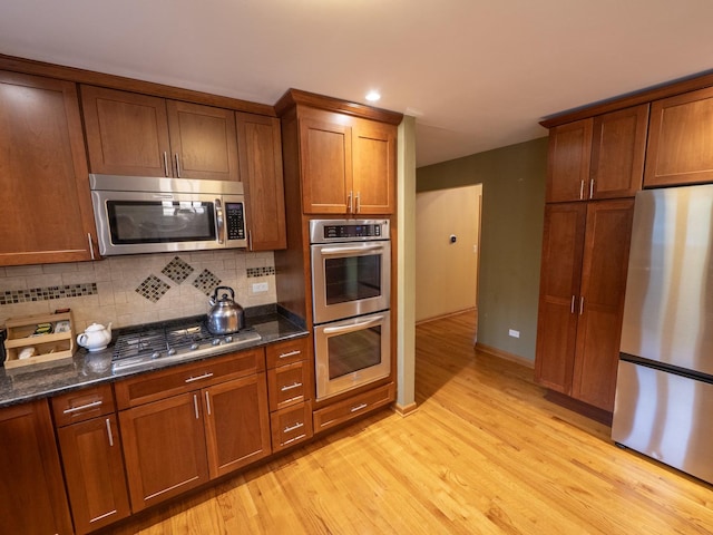 1707 Frediani Ct, Mount Prospect, IL 60056 - kitchen featuring appliances with stainless steel finishes, light wood-style flooring, decorative backsplash, brown cabinetry, and recessed lighting