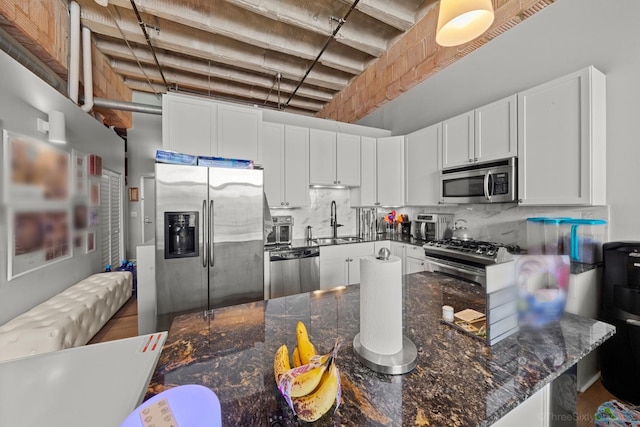 2545 S Dearborn St Unit 405, Chicago, IL 60616 - kitchen featuring stainless steel appliances, white cabinets, tasteful backsplash, and dark stone countertops