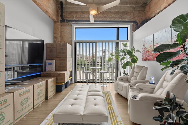 2545 S Dearborn St Unit 405, Chicago, IL 60616 - living room featuring light wood-style flooring, brick wall, and a towering ceiling