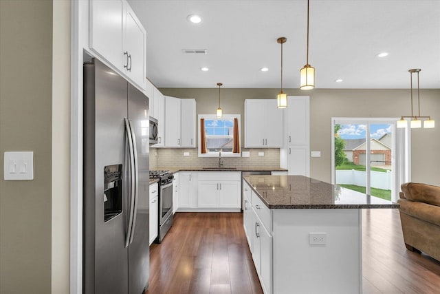 3311 Memory Ln E, Unit East, Urbana, IL 61802 - kitchen with stainless steel appliances, a kitchen island, backsplash, a sink, and dark stone counters