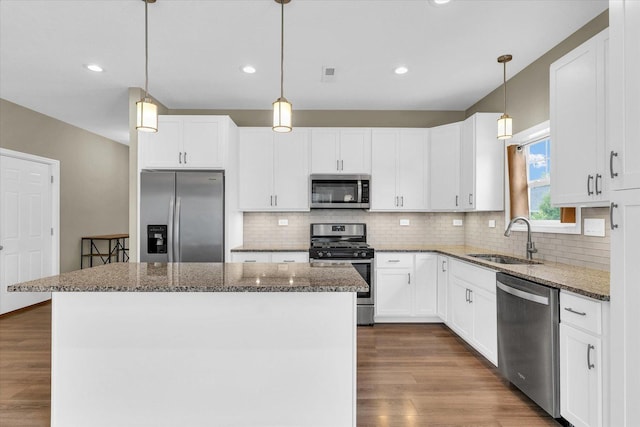 3311 Memory Ln E, Unit East, Urbana, IL 61802 - kitchen with appliances with stainless steel finishes, a sink, a kitchen island, dark wood-style flooring, and white cabinets
