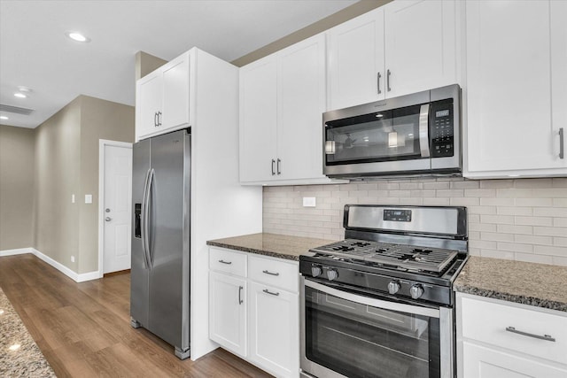 3311 Memory Ln E, Unit East, Urbana, IL 61802 - kitchen with appliances with stainless steel finishes, wood finished floors, dark stone counters, white cabinetry, and recessed lighting