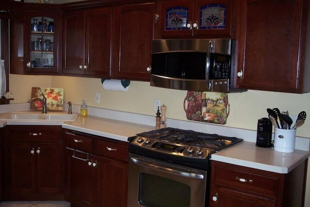 236 S Randolph St, Princeton, IL 61356 - kitchen featuring stainless steel appliances, ornamental molding, light countertops, glass insert cabinets, and light tile patterned floors