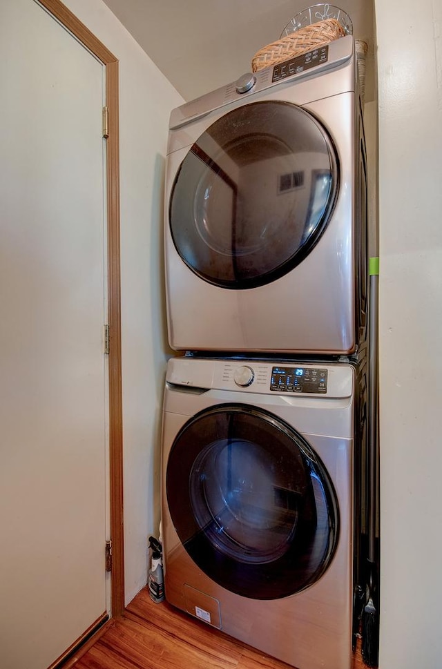 14005 Danbury Dr, Plainfield, IL 60544 - laundry area featuring stacked washing machine and dryer and wood finished floors