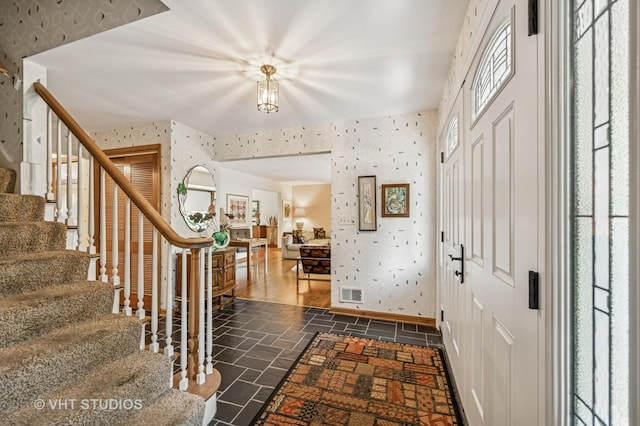 2620 Marian Ln, Wilmette, IL 60091 - entrance foyer featuring wallpapered walls, stairs, and dark stone finish flooring