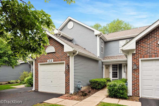1312 Shawford Way Unit 1312, Elgin, IL 60120 - traditional home featuring an attached garage, driveway, brick siding, and roof with shingles