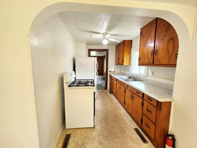 1198 E Bluff St, Marseilles, IL 61341 - kitchen with white appliances, brown cabinets, light countertops, a ceiling fan, and arched walkways