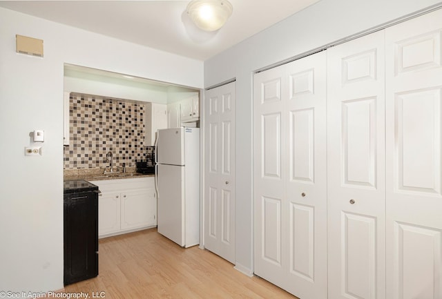 417 S Kenilworth Ave Unit 7, Oak Park, IL 60302 - kitchen featuring freestanding refrigerator, stove, light wood-style flooring, decorative backsplash, and white cabinetry