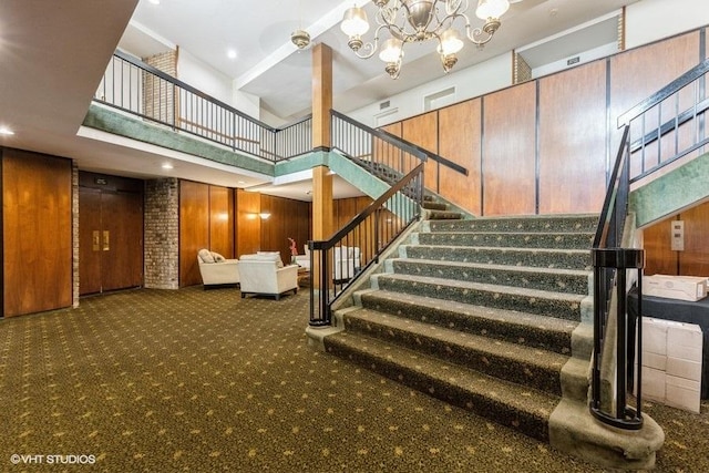 6700 S Brainard Ave Unit 104, Countryside, IL 60525 - stairway with carpet floors, wooden walls, a chandelier, and a towering ceiling