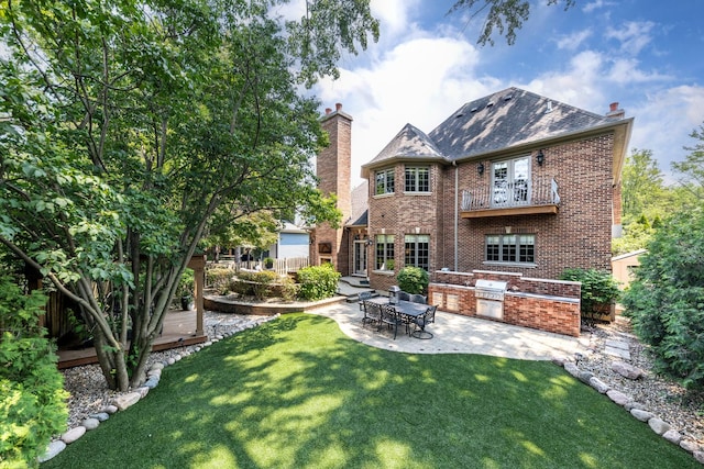 655 Thornwood Dr, Naperville, IL 60540 - back of property featuring exterior kitchen, a chimney, brick siding, and a deck