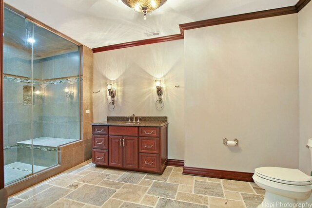273 Donlea Rd, Barrington Hills, IL 60010 - bathroom featuring stone tile floors, crown molding, toilet, vanity, and a stall shower