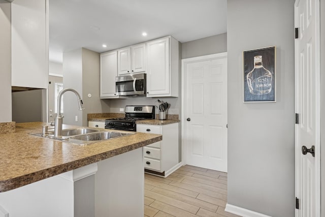 830 E Hillside Ave Unit 830, Barrington, IL 60010 - kitchen featuring appliances with stainless steel finishes, light wood-style flooring, recessed lighting, white cabinets, and a peninsula