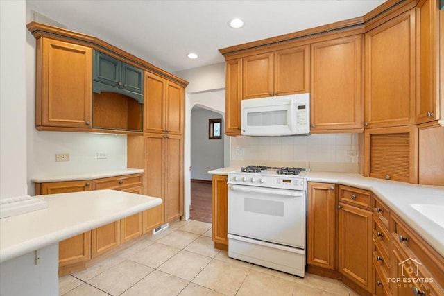 1176 S Maple Ave, Oak Park, IL 60304 - kitchen featuring white appliances, arched walkways, tasteful backsplash, recessed lighting, and light tile patterned flooring