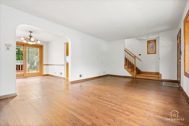 1176 S Maple Ave, Oak Park, IL 60304 - unfurnished living room featuring a chandelier, light wood-style floors, arched walkways, and baseboards