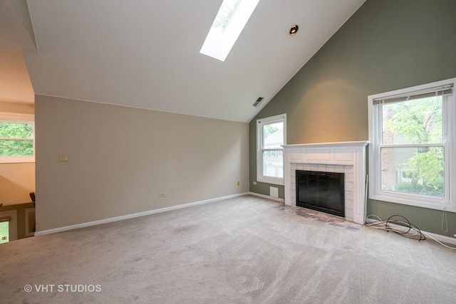 1949 N Charter Point Dr Unit 0, Arlington Heights, IL 60004 - unfurnished living room featuring carpet floors, baseboards, a tiled fireplace, a skylight, and high vaulted ceiling