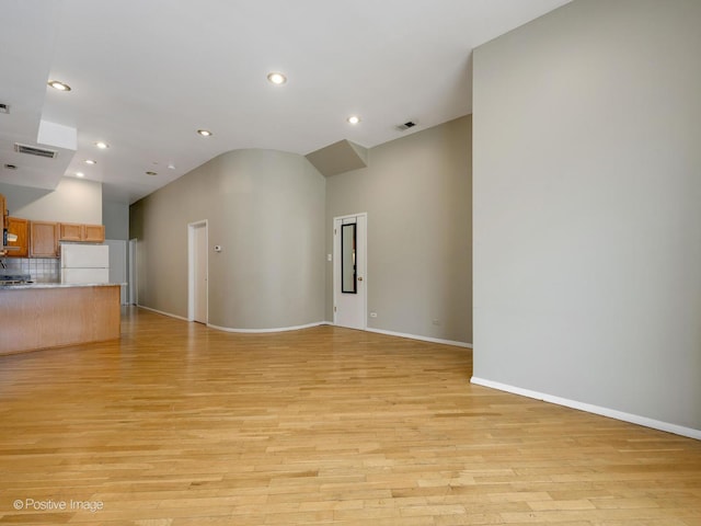 2023 W Armitage Ave, Chicago, IL 60647 - unfurnished living room with light wood-style floors, recessed lighting, and vaulted ceiling
