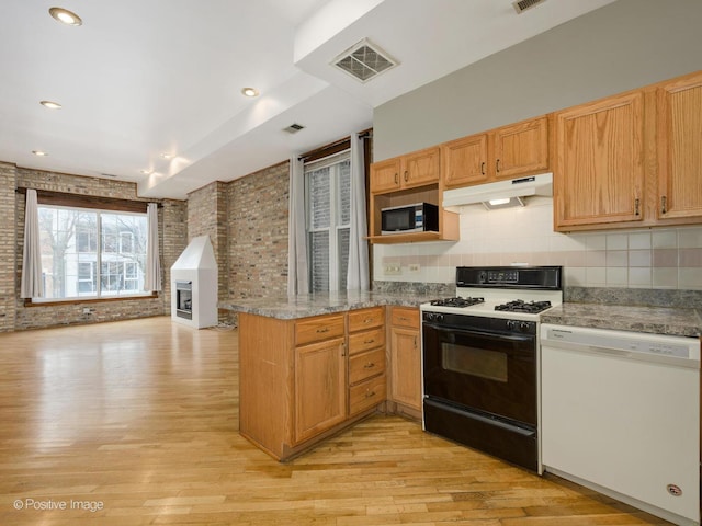 2023 W Armitage Ave, Chicago, IL 60647 - kitchen featuring range with gas stovetop, white dishwasher, under cabinet range hood, a peninsula, and stainless steel microwave