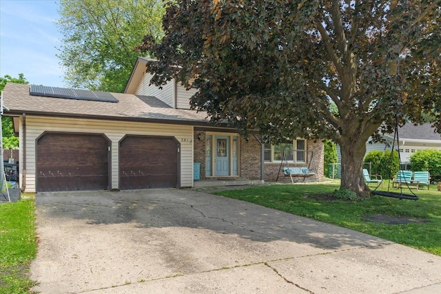 391 Northgate Rd, Lindenhurst, IL 60046 - view of front of home featuring an attached garage, solar panels, concrete driveway, a front yard, and brick siding