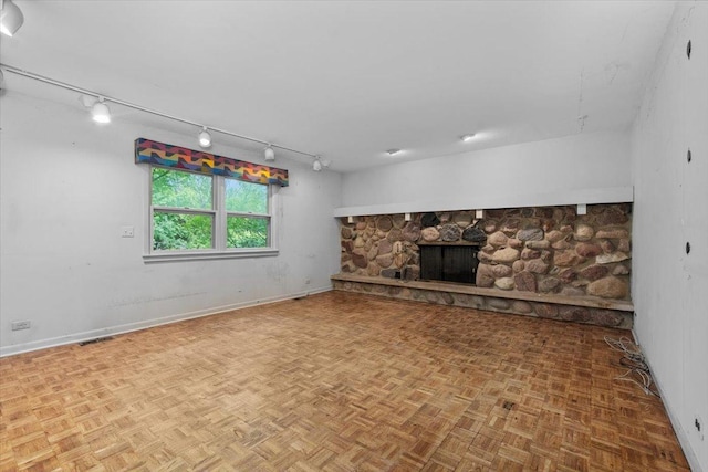 3227 River Falls Dr, Northbrook, IL 60062 - unfurnished living room featuring rail lighting, a stone fireplace, and baseboards