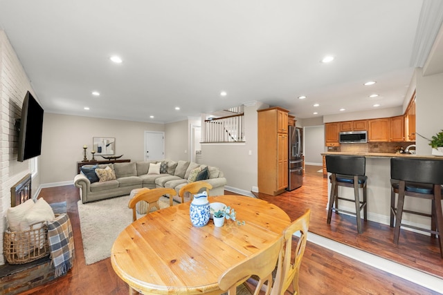 389 Pearson Cir, Naperville, IL 60563 - dining area featuring recessed lighting, wood finished floors, stairway, a fireplace, and ornamental molding