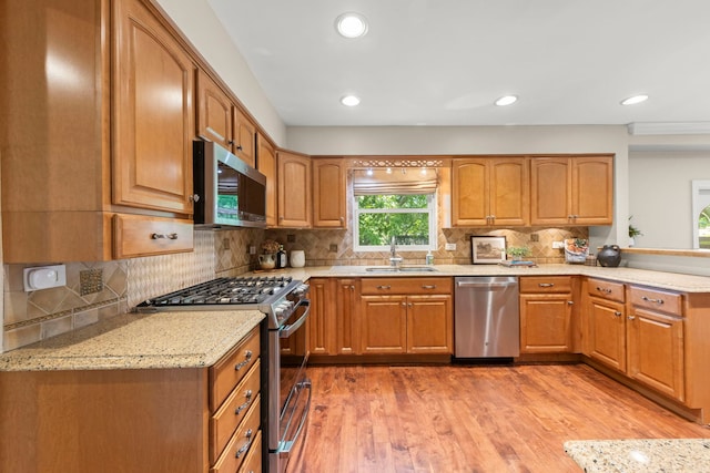 389 Pearson Cir, Naperville, IL 60563 - kitchen with appliances with stainless steel finishes, light stone countertops, light wood-style floors, decorative backsplash, and recessed lighting